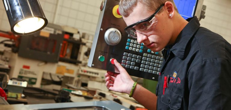 cnc operator pushing button on control panel