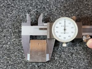 dial caliper measuring 1 inch block