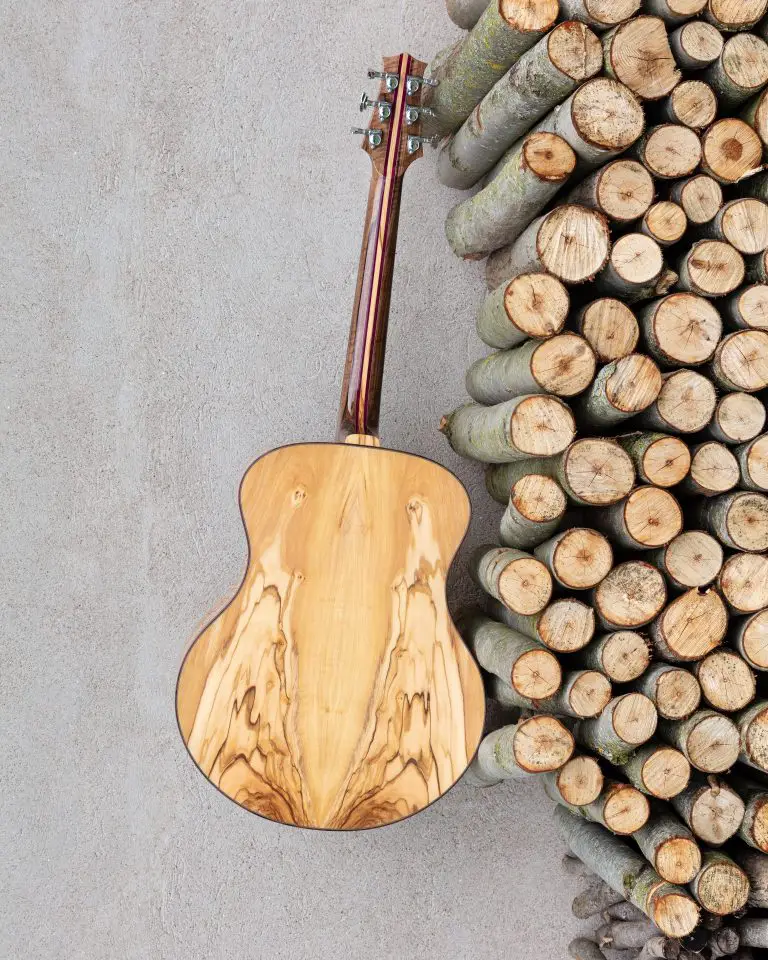 the back of a guitar near a bunch of cut wood